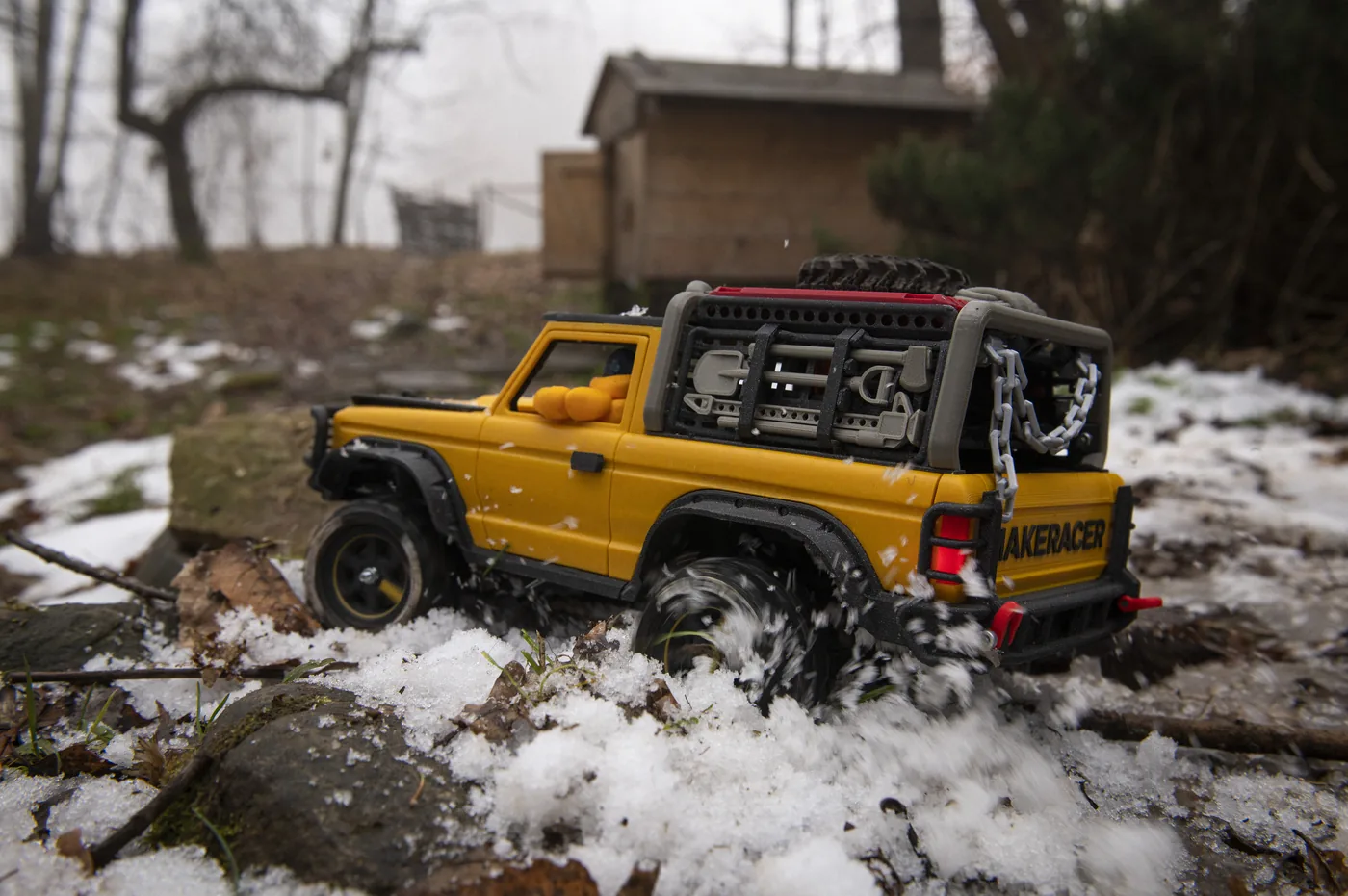 MAKERACER driving through snow on logs